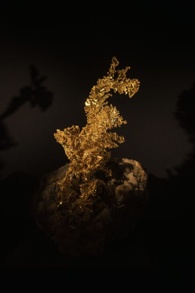 Stunning macro shot of a natural gold nugget against a dark background, highlighting its texture and luster.