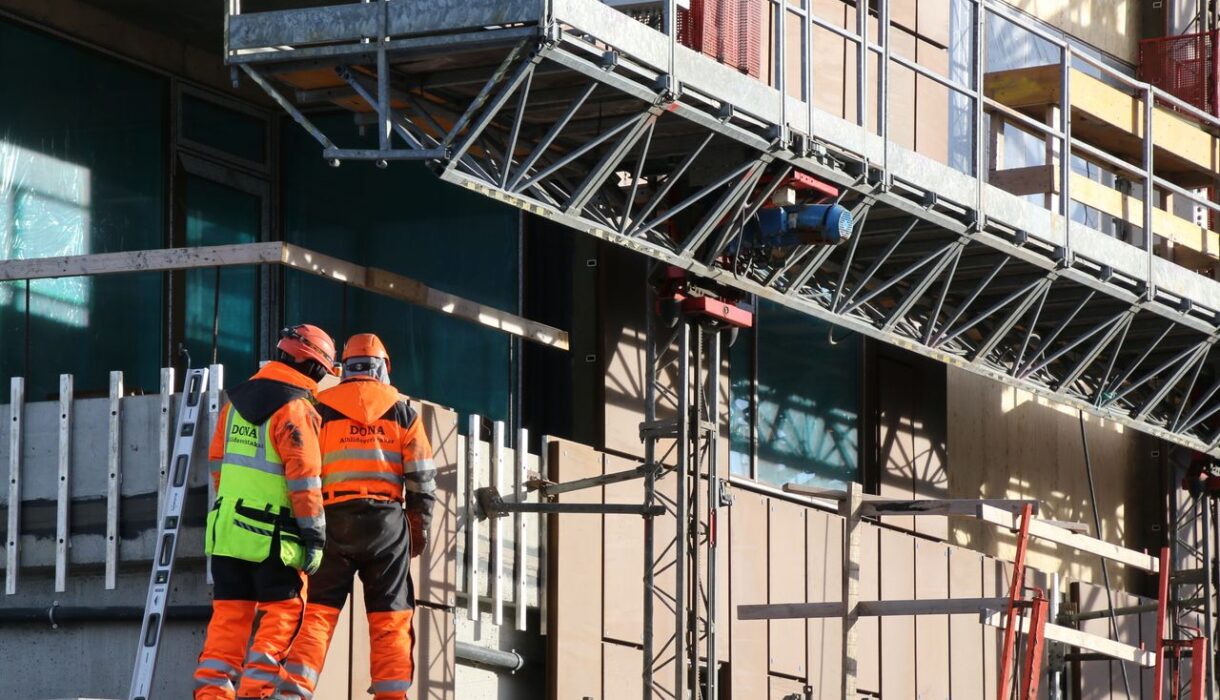 Construction workers in high-visibility clothing on a skyscraper in Reykjavík, Iceland.