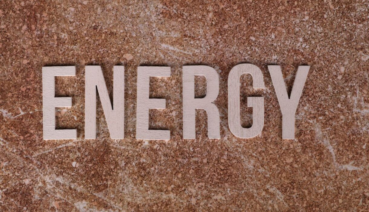 Word 'Energy' on natural stone texture, symbolizing raw power.